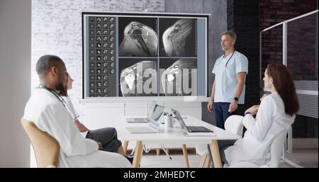 Physician Doctors Looking At Shoulder MRT Scan Stock Photo