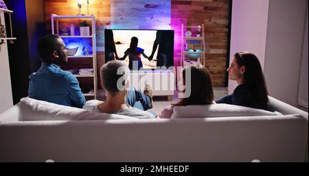 Couples Watching TV At Night. Television Screen Stock Photo