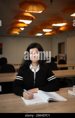 PRODUCTION - 24 January 2023, Hesse, Frankfurt/Main: Irina Ushakova, a nurse from Ukraine, sits in a classroom at the Talent Orange nursing agency. Thousands of Ukrainians have found work in Hesse after fleeing the war in their homeland. One of them is Irina Ushakova, a trained nurse. (to dpa-KORR Professional new start after flight: 'Now a new chapter begins') Photo: Sebastian Gollnow/dpa Stock Photo