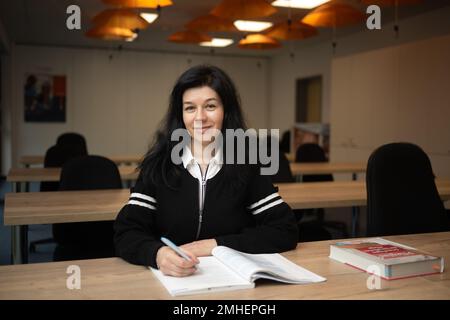 PRODUCTION - 24 January 2023, Hesse, Frankfurt/Main: Irina Ushakova, a nurse from Ukraine, sits in a classroom at the Talent Orange nursing agency. Thousands of Ukrainians have found work in Hesse after fleeing the war in their homeland. One of them is Irina Ushakova, a trained nurse. (to dpa-KORR Professional new start after flight: 'Now a new chapter begins') Photo: Sebastian Gollnow/dpa Stock Photo