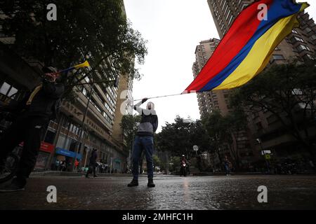 A demonstrator waves a Colombian national flag where Dilan Cruz was injured during clashes between anti-government protesters and security forces, in Bogota, Colombia, Tuesday, Nov. 26, 2019. Cruz, an 18-year-old high school student, died two days after being hit in the head by a projectile reportedly fired by riot police during a protest. (AP Photo/Fernando Vergara)