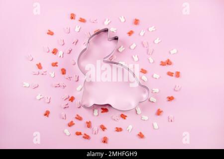 Easter decoration with bunny and sugar sprinkle on a pink background.top view. space for text. Stock Photo