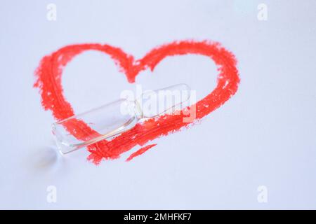 glass ampoule with heart painted red lipstick on a white Stock Photo