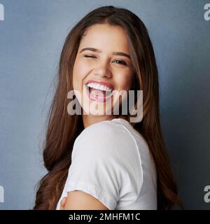 Dont be afraid to sparkle a little brighter. Studio shot of an attractive young woman posing against a gray background. Stock Photo