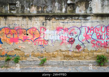 The exterior wall of the Caserma Garibaldi army barracks, covered in tagged words, messy layers. An example of graffiti in Naples, Napoli, Italy, Ital Stock Photo
