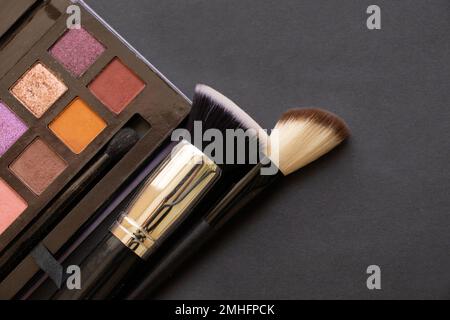 multi-colored eyeshadows for make-up and brushes on a dark background, beauty fashion makeup Stock Photo
