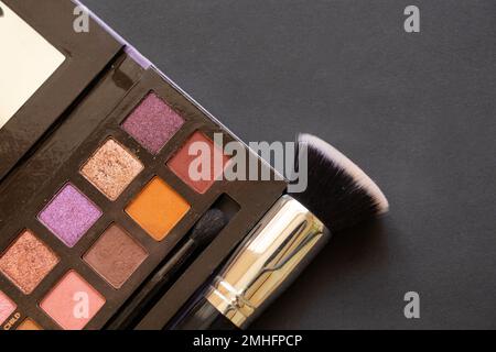 multi-colored eyeshadows for make-up and brushes on a dark background, beauty fashion makeup Stock Photo