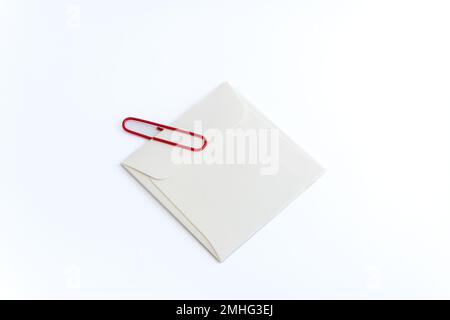 White envelope and Red Clip on white background with Clipping Path. Announcement, bulletin, newsletter, important note concept. Stock Photo