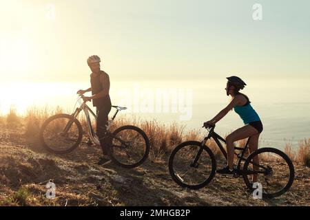Experience the excitement with someone you love. a happy young couple out mountain biking together. Stock Photo
