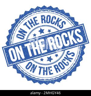 ON THE ROCKS, text written on blue-black grungy postal stamp Stock ...