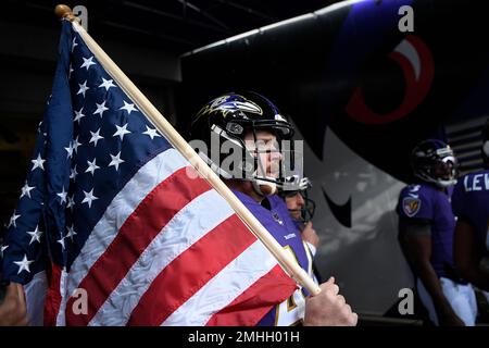 Baltimore Ravens long snapper Morgan Cox (46) waits to take the field while  holding a flag as part of the team's Salute to Service prior to an NFL  football game against the