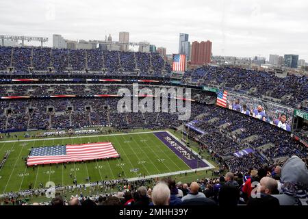 U.S. service members hold a large flag on the field at M&T Bank