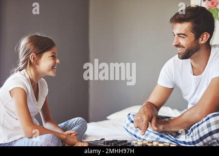 Doesnt matter who wins as long as we having fun. a young father playing a board game with his adorable little daughter at home. Stock Photo