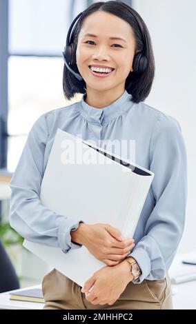 Portrait, portfolio or happy manager in a call center with a smile or file documents in customer services. Woman, contact us or Japanese telemarketing Stock Photo