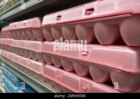 Rows of pink styrofoam egg cartons on a grocery store shelf. Stock Photo