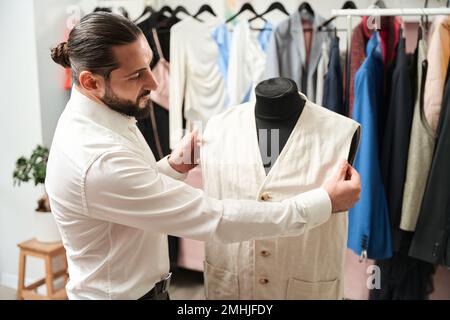 Concentrated fashion designer working on new vest Stock Photo