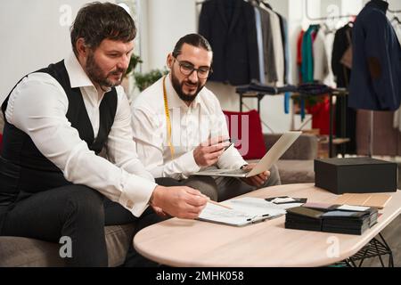 Experienced fashion designers working on new men clothing collection Stock Photo
