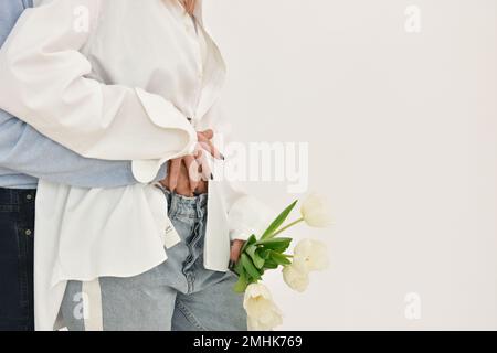 Loving couple holding a bouquet of tulips on a white background. Stock Photo
