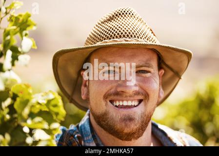 Each day is a chance to plant and grow some happiness. Portrait of a farmer standing in a vineyard. Stock Photo