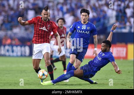 Al Hilal's Ali Al Bulayhi, right, fights for the ball with Urawa