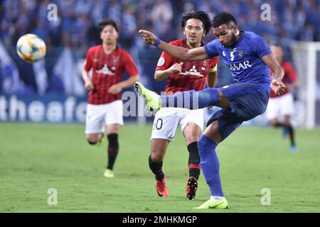 Al Hilal's Ali Al Bulayhi, right, fights for the ball with Urawa