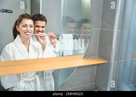 Young couple in the bathroom in hotel brushing their teeth Stock Photo