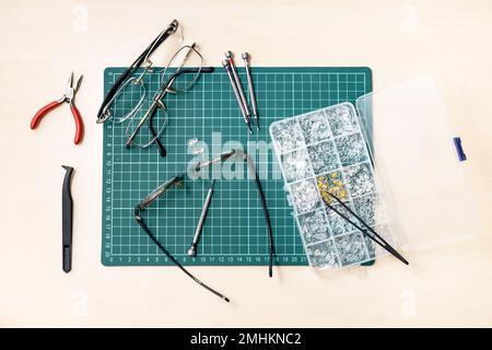 top view of kit for repairing used eyeglasses on wooden table Stock Photo