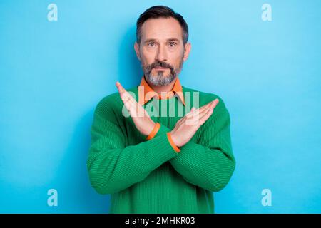 Photo portrait of mature handsome man showing stop gesture crossed hands dressed stylish green clothes isolated on blue color background Stock Photo