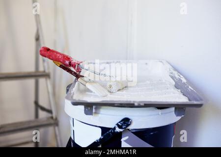 Still life of home painting project - brush, roller, paint tray, bucket, ladder Stock Photo