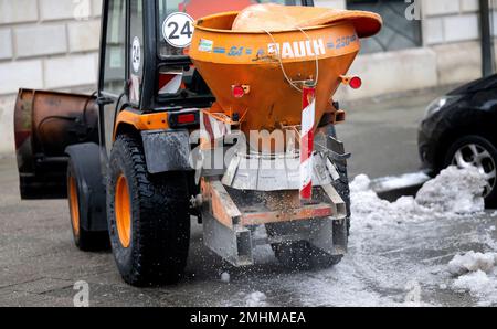 Munich, Germany. 27th Jan, 2023. A snow removal vehicle drives over a sidewalk in the city center. The German Weather Service (DWD) warns of black ice for the area of the state capital. Credit: Sven Hoppe/dpa/Alamy Live News Stock Photo