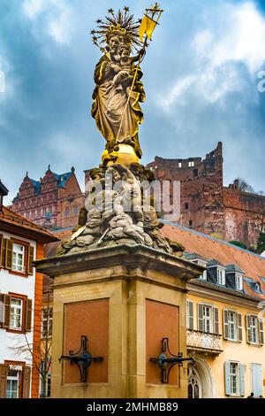 The Muttergottesbrunnen fountain with the Madonna statue on the square Kornmarkt (Corn Market) in the old town of Heidelberg, Germany. In the... Stock Photo