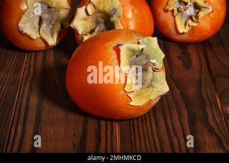 persimmon on brown wood background Stock Photo