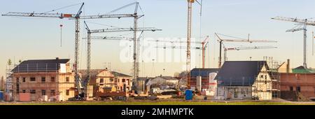 cranes on a construction site of residential homes Stock Photo
