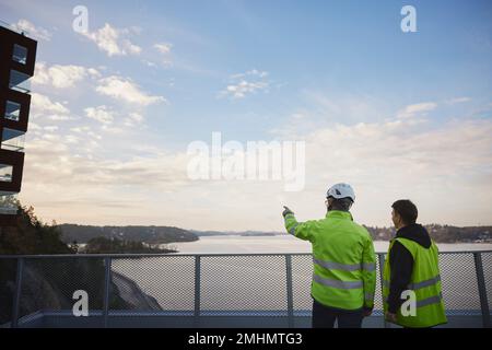 Engineers in reflective clothing talking outdoors Stock Photo
