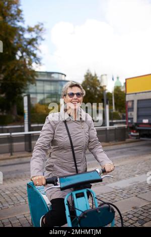 Happy woman on city bicycle Stock Photo