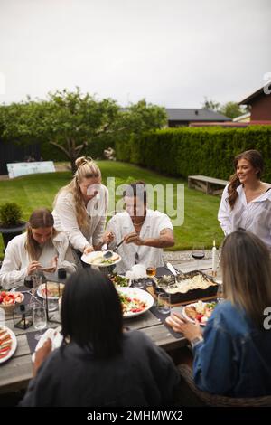 Friends having meal in garden Stock Photo