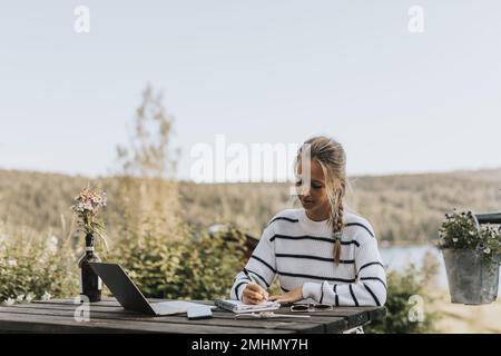 Young woman taking notes Stock Photo
