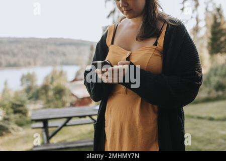 Mid section of woman using cell phone Stock Photo