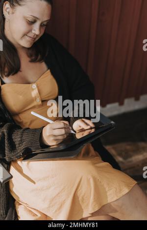Smiling woman using digital tablet Stock Photo