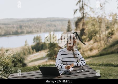 Young woman taking notes Stock Photo