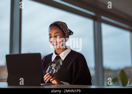 Smiling young woman working on laptop Stock Photo