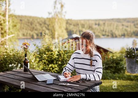 Smiling woman taking notes Stock Photo