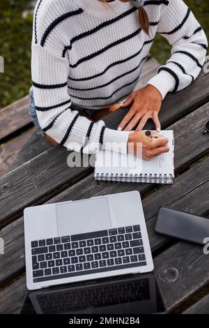 Mid section of woman writing in notepad Stock Photo