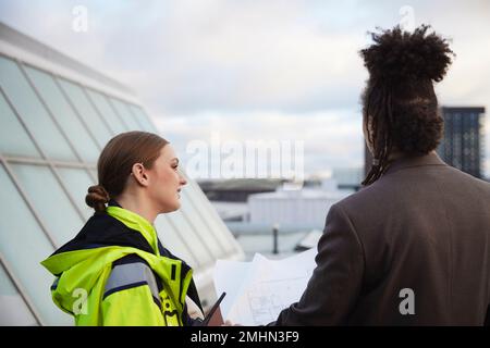 Architects talking while holding blueprints Stock Photo