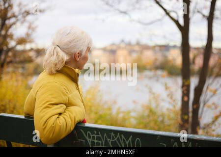 Young woman on bench looking away Stock Photo