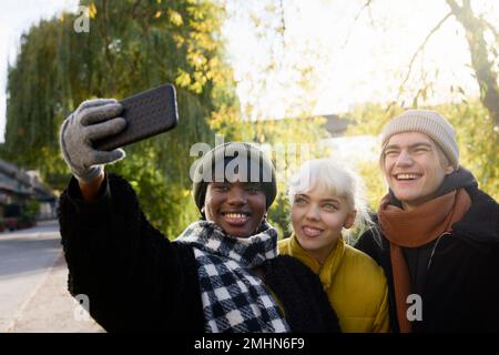 Smiling young friends taking selfie Stock Photo