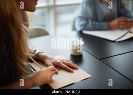 Woman taking notes during meeting Stock Photo