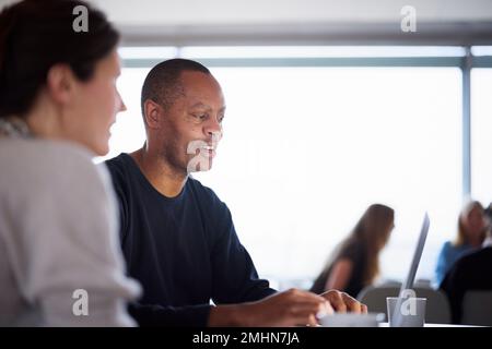 Smiling man talking in cafeteria Stock Photo