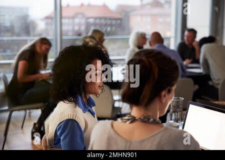 Women talking in cafeteria Stock Photo