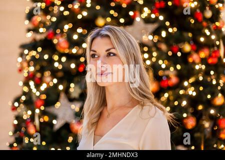 Young woman posing next to christmas tree Stock Photo